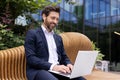 Confident businessman working on laptop at outdoor city park, professional with tech Royalty Free Stock Photo