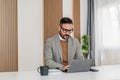 Confident businessman working on laptop while sitting at office desk Royalty Free Stock Photo