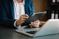 Businessman working on laptop and tablet at her workplace at modern office