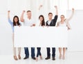 Confident businesspeople holding blank billboard Royalty Free Stock Photo