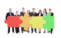 Confident businesspeople joining jigsaw puzzle pieces Royalty Free Stock Photo