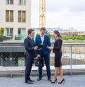 Confident businesspersons talking in front of modern office building. Businessman and businesswoman have business Royalty Free Stock Photo