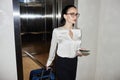 Confident Businesswoman Exiting Elevator with Suitcase Royalty Free Stock Photo