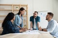 Confident businesswoman mentor speaks in coworking boardroom at meeting.