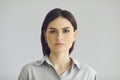 Young thoughtful serious caucasian woman face portrait on studio grey background Royalty Free Stock Photo