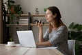 Confident businesswoman recording audio message, sitting at desk with laptop