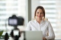 Confident businesswoman recording video course on camera