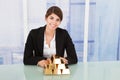 Confident Businesswoman Showing Stacked Gold Blocks On Desk