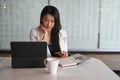 Businesswoman sitting at her workplace and holding smart phone. Royalty Free Stock Photo