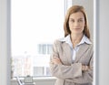 Confident businesswoman smiling in bright office