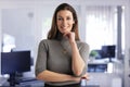 Confident businesswoman standing in a modern office and wearing casual clothes Royalty Free Stock Photo
