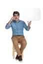 Confident casual man talking on phone and holding speech bubble Royalty Free Stock Photo