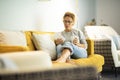 Confident caucasian adult woman sitting on the sofa reading a book using electronic device tablet reader. Pretty female people