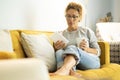 Confident caucasian adult woman sitting on the sofa reading a book using electronic device tablet reader. Pretty female people