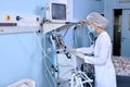 Confident Female Doctor Setting Up Medical Equipment Device For Treating Patient