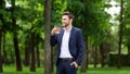 Confident CEO with takeout coffee enjoying his morning walk at urban park Royalty Free Stock Photo