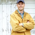 Confident and in charge. Portrait of a smiling man with his arms crossed standing outside a shed. Royalty Free Stock Photo