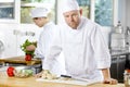 Confident chef making food in large kitchen Royalty Free Stock Photo