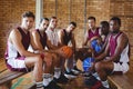 Confident coach and basketball player sitting on bench