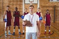 Confident coach and basketball player standing in the court