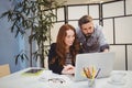 Confident colleagues using laptop at creative office Royalty Free Stock Photo