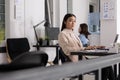 Confident company employee working on laptop in coworking space