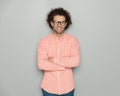 confident curly hair man with glasses smiling and crossing arms Royalty Free Stock Photo