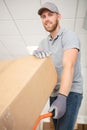 confident delivery man pushing parcels on handtruck