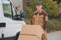 Confident Delivery Man Pushing Parcels On Handtruck