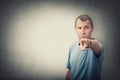 Confident and determined middle age man pointing index finger to camera, like blaming or accuse someone, isolated on grey wall Royalty Free Stock Photo