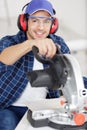 Confident diligent friendly workman ready to working on circular saw