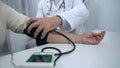 Confident doctor checking blood pressure of patient and giving advices, health