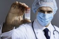 Confident doctor in face mask holding pills box Royalty Free Stock Photo