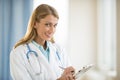 Confident Doctor Holding Clipboard In Clinic Royalty Free Stock Photo