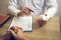 Confident doctor man holding a pill bottle and talking with senior patient and reviewing his medication at office room