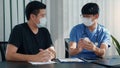 Confident doctor man holding a pill bottle while talking with a senior patient and reviewing his medication at office room Royalty Free Stock Photo