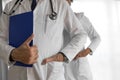 Confident doctors with hands in pockets against white background Royalty Free Stock Photo