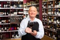 Confident elderly male winemaker inviting to wine house, offering glass of wine for tasting Royalty Free Stock Photo