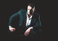 Confident elegant handsome young business man in a studio wearing a suit.