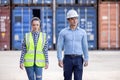 Confident engineers portrait in uniforms standing in front of the containers. Logistics and shipping. Professional occupation Royalty Free Stock Photo