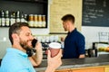 Confident entrepreneur choose drink in paper cup to go while communicate mobile. Man speak mobile phone and drink coffee Royalty Free Stock Photo