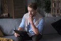 Confident European business male working remotely use laptop on couch at cozy living room Royalty Free Stock Photo