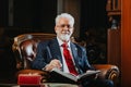 Confident and experienced university rector poses in modern university office. His success radiates in the college.