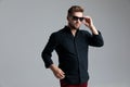 Confident fashion man taking off his sunglasses and looking away Royalty Free Stock Photo