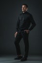 Confident fashionable man posing in black outfit