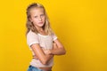 Confident fashionable teenage girl posing over yellow studio background, with copy space. Summer fashion. Beautiful schoolgirl