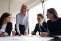 Confident female boss head meeting with colleagues in office