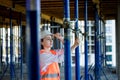 Confident Female builder checks fastenings on a monolithic structure. Construction concept Royalty Free Stock Photo