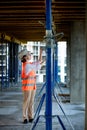 Confident Female builder checks fastenings on a monolithic structure. Construction concept Royalty Free Stock Photo