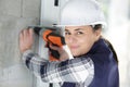 confident female builder drilling wall Royalty Free Stock Photo